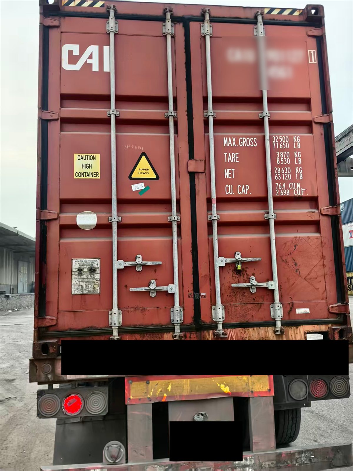 Closed shipping container on truck with sensitive details masked